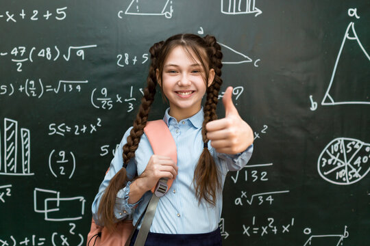 Happy teenage schoolgirl rejoices at a good result in an exam, concept success in school life.