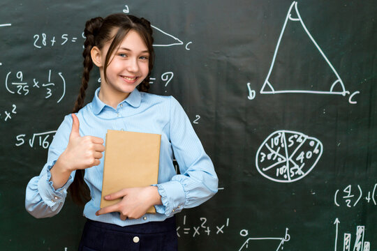 Happy teenage schoolgirl rejoices at good result in an exam, concept of success in school life.