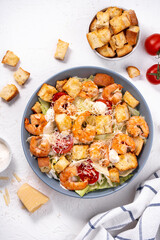 Shrimp Caesar Salad in a Bowl with Parmesan Cheese, Dressing and Croutons