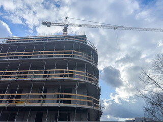 Fototapeta na wymiar Crane and building under construction. Housing construction, apartment block