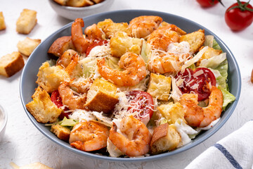 Shrimp Caesar Salad in a Bowl with Parmesan Cheese, Dressing and Croutons