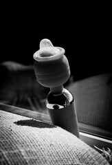 A dildo with a condom, an intimate toy for women.
Vibrator for pleasure.
Black and white photo - obrazy, fototapety, plakaty