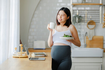 pregnancy, healthy food and people concept - close up of happy pregnant woman eating vegetable...