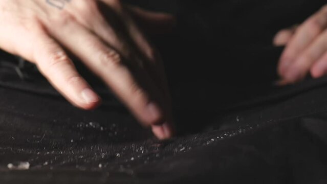 Water dripping onto waterproof fabric. Water jet on water resistant jacket. drops of water on water-repellent clothing