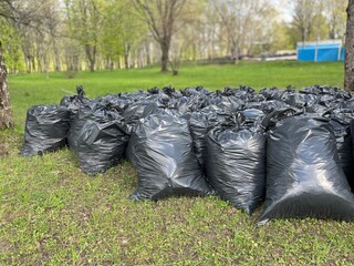 black garbage bags after cleaning in a nature park in early spring, The concept of eco-friendly behavior and preservation of the purity of the environment