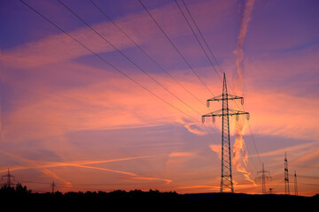 beautiful sunset landscape, sky with airplane trail lines, power towers, power production, beauty...