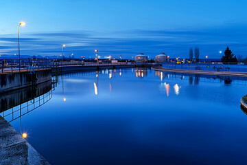 Fototapeta na wymiar Twilight Blue Hour at Industrial Water Treatment Plant with Reflective Pools and Illuminated Lights