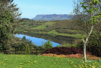 Landscape in rural County Sligo, Ireland featuring Benbulben Mountain and Lough Colgagh viewed from garden on bright late spring day