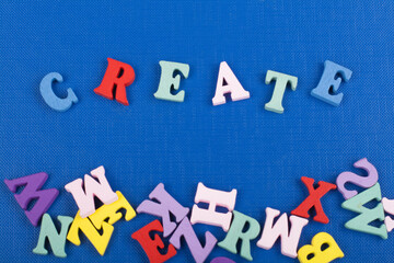 CREATE word on blue background composed from colorful abc alphabet block wooden letters, copy space for ad text. Learning english concept.