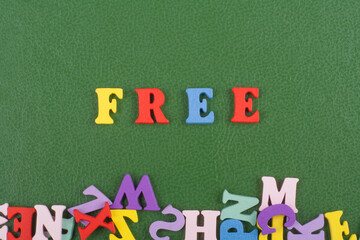 FREE word on green background composed from colorful abc alphabet block wooden letters, copy space...