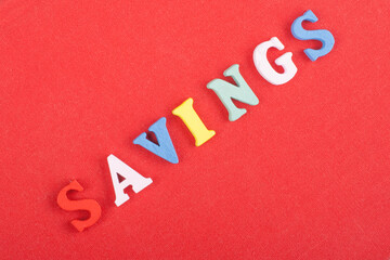 SAVINGS word on red background composed from colorful abc alphabet block wooden letters, copy space...