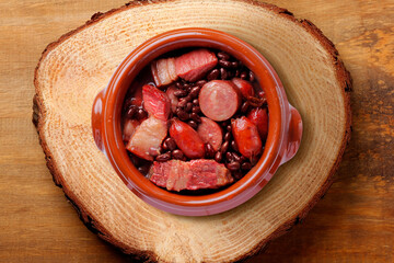 brazilian feijoada in ceramic bowl isolated on rustic wooden background. Copy space