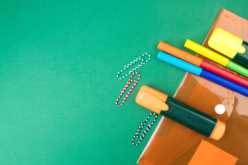 Back to school. Stationery on a green table. Office desk with copy space. Flat lay.