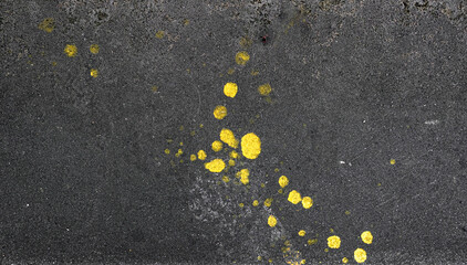 Concrete pavement with drops of yellow paint texture
