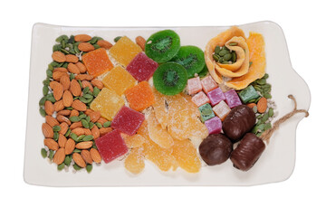 Variety of sweet desserts in plate for the holiday. Marmalade, candied fruit, mango, kiwi, nuts,...