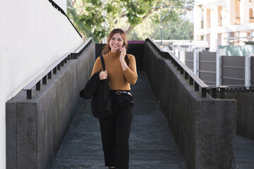 A woman is talking on her cell phone while walking down a stairway