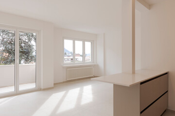 Empty interior of a room, living room of a private flat.   The space is new and in the background two large windows