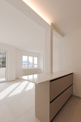 Empty interior of a room, living room of a private flat.   The space is new and in the background two large windows.