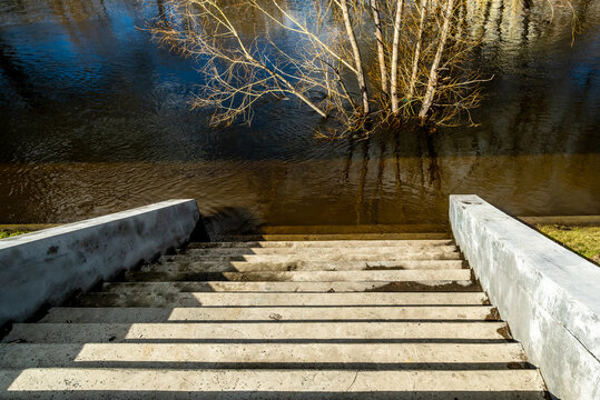 A stone staircase leading to the river in the park.