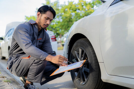 Young man checks broken car on the side of the road, long distance driving concept. Portrait of an Asian auto mechanic, auto repair, car service. and maintenance concept