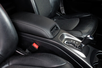 Armrest in the car for driver. Car armrest. Armrest between front seats inside the car. Luxury car interior background.