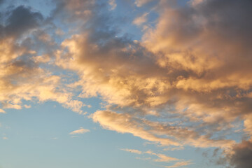 A fragment of a bright sunset sky with bizarrely shaped clouds