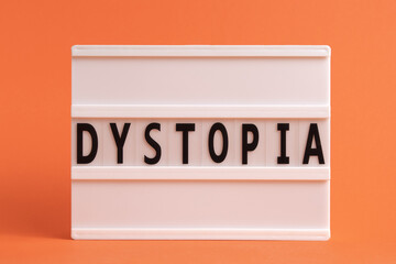 The word Dystopia on lightbox isolated orange background. Literary Genres