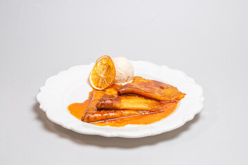Treat yourself to luxurious pancakes with orange sauce and creamy ice cream on a white background....