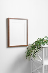 Blank picture frame mockup with copy space for design on white wall with eucalyptus twigs