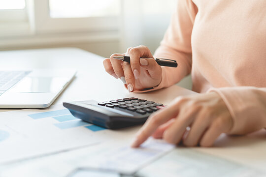 Deduction planning, debt asian young woman  hand using calculator to calculating money balance from bill and income, cost budget expenses for pay money form personal individual on table at home.