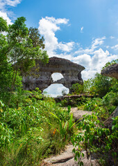 Iconic Puerta de Orion rock formation amidst lush greenery under a cloudy sky in San Jose del...