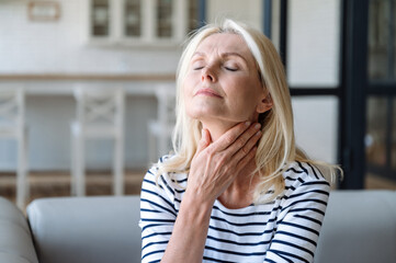 Mature woman with inflammation lymph nodes feeling throat sore