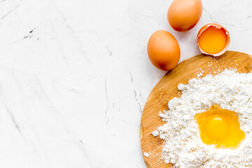 Making dough concept. Pile of flour and eggs on white background top view copy space