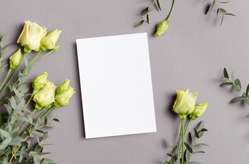Blank invitation or greeting card mockup with fresh flowers, mockup with copy space