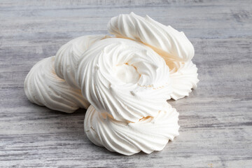 a pile of white meringue nests on a grey table top