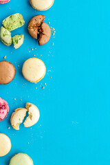 Brignt macarons for sweet break on blue background top view mock up