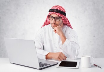 A saudi character using laptop  on withe background