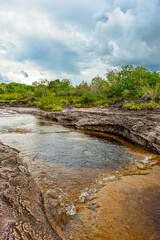 Rocky landscape in Natural Wells, lush vegetation under a cloudy sky in San José del Guaviare,...