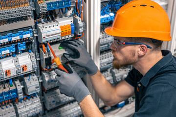 Male electrician working in a switchboard with fuses.