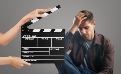 Actor performing on background of film clapperboard