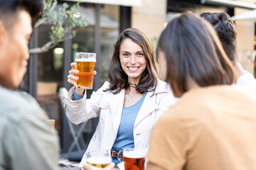 Cheerful woman toasting with friends at a pub. A moment of joy and camaraderie, captured as...