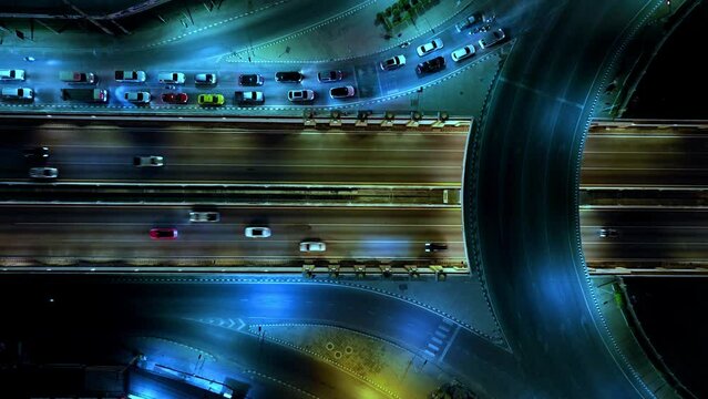 Beautiful top view time-lapse of car traffic at roundabout lane and buildings. drone aerial expressway. Urban cityscape concept or abstract of advanced innovation, financial technology, energy power