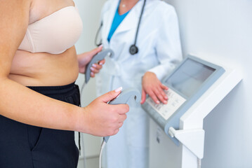 Obese young woman undergoes a body composition analysis with a professional health expert