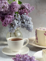 cup of tea and lilac flowers