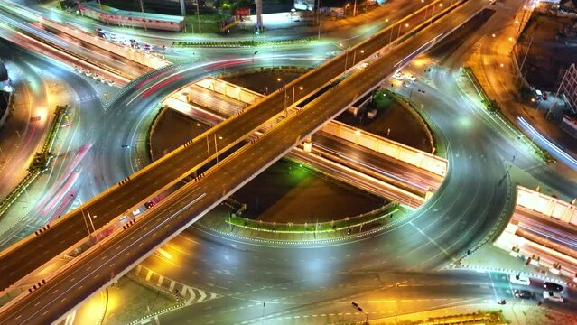 Beautiful top view time-lapse of car traffic at roundabout lane and buildings. drone aerial expressway. Urban cityscape concept or abstract of advanced innovation, financial technology, energy power