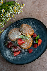 Pancakes with powdered sugar and berries for breakfast 
