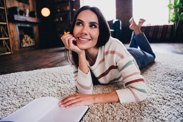 Photo of dreamy shiny lady dressed striped sweater lying floor writing ideas copybook indoors house...