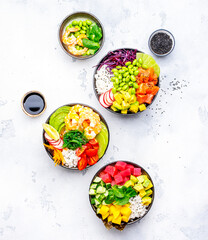 Poke bowls with vegetables and seafood in assortment, white table background, top view - 791862375