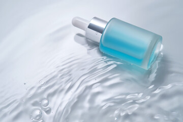 Bottles of cosmetics with a dropper in water on a blue background.