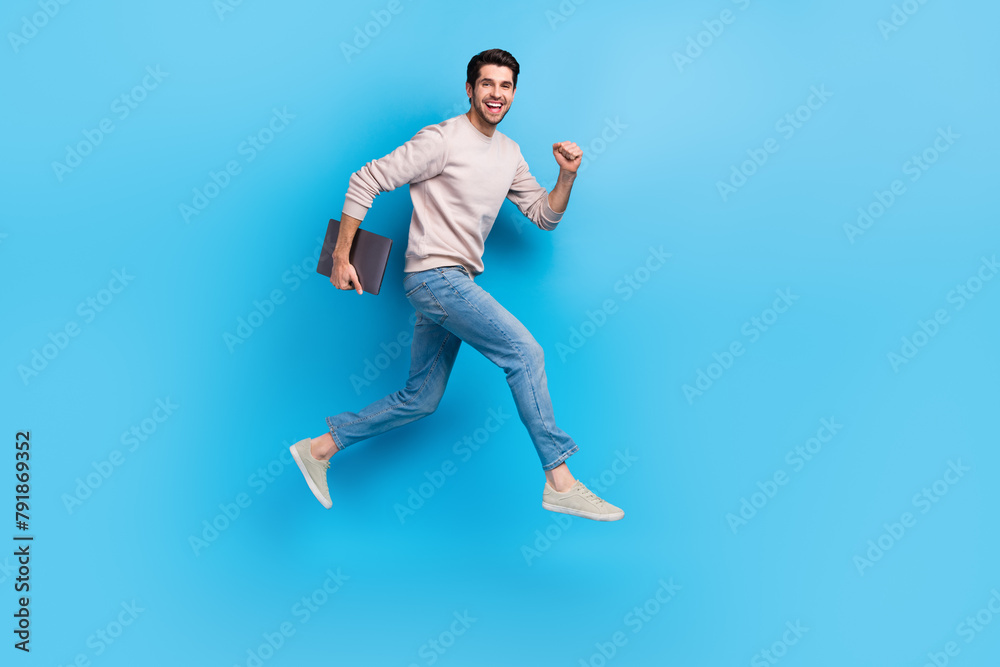 Poster full size photo of optimistic cheerful man wear sweatshirt denim pants run to empty space with lapto